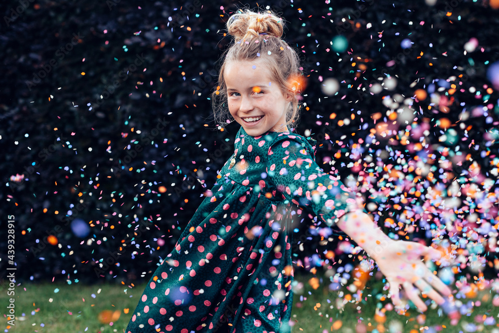 beautiful smiling little girl under a shower of confetti - birthday party carefree celebration concept - obrazy, fototapety, plakaty 
