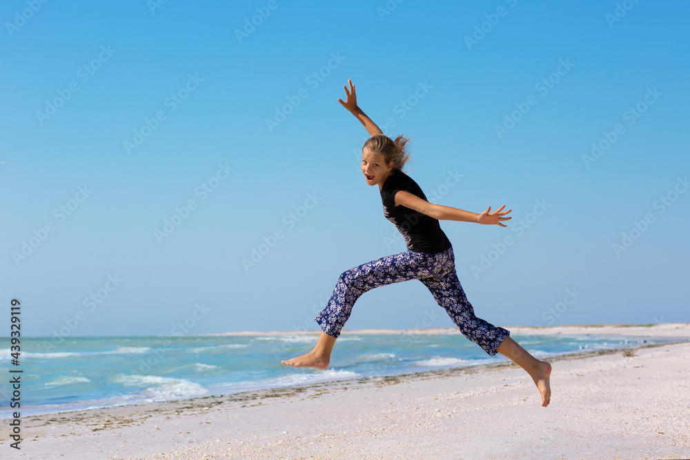 Happy girl jumping on the beach