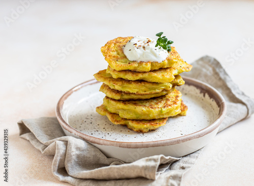 Obraz na plátně Stack of vegetable fritters or pancakes with yoghurt or cream sour dressing and herbs