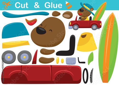 Cartoon of funny bear wearing hat on car carrying surfboard. Education paper game for children. Cutout and gluing