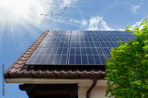 Concept clean power energy - solar panel on the roof. Green tree. Solar photovoltaic panels on a house roof. ECO CONCEPTUAL photo