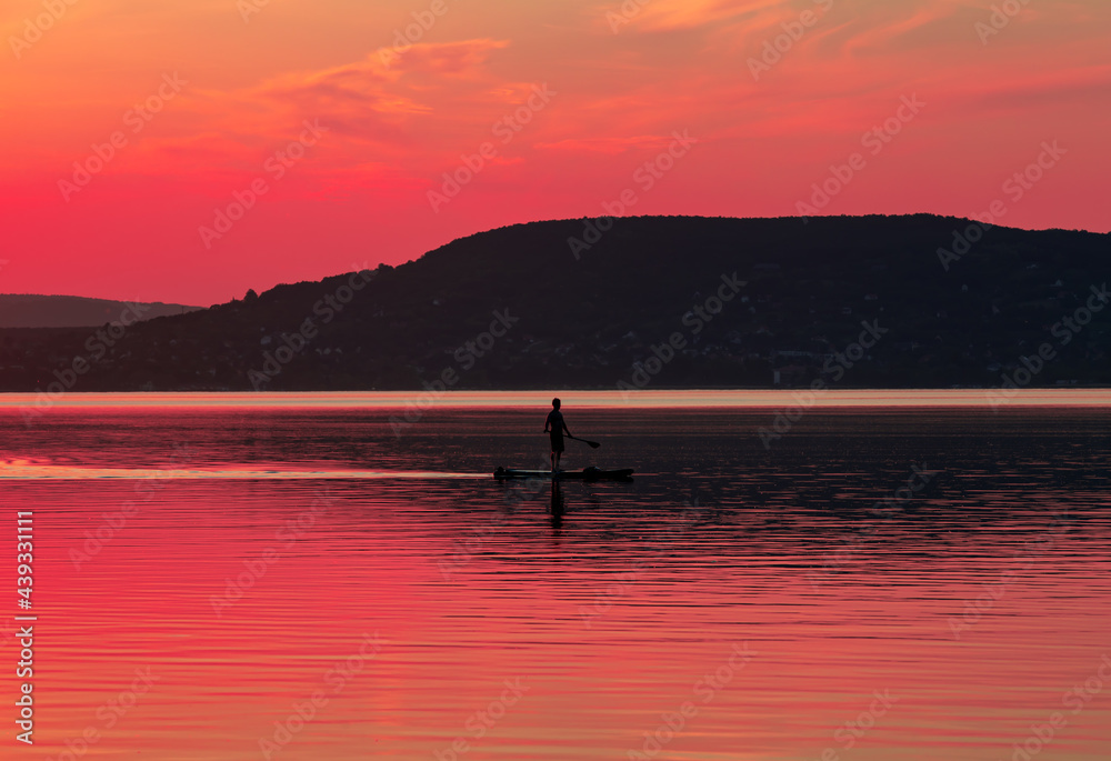 a young man doing paddleboarding on the lake