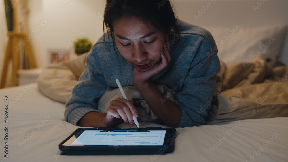 Freelance Asia women casual wear using laptop hard work on bed in bedroom at house night. Working from home, remotely work, self isolation, social distancing, quarantine for coronavirus prevention. Freelance Asia women casual wear using laptop hard work on bed in bedroom at house night. Working from home, remotely work, self isolation, social distancing, quarantine for coronavirus prevention.