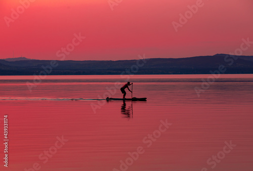 a man on a raft in the evening on the lake