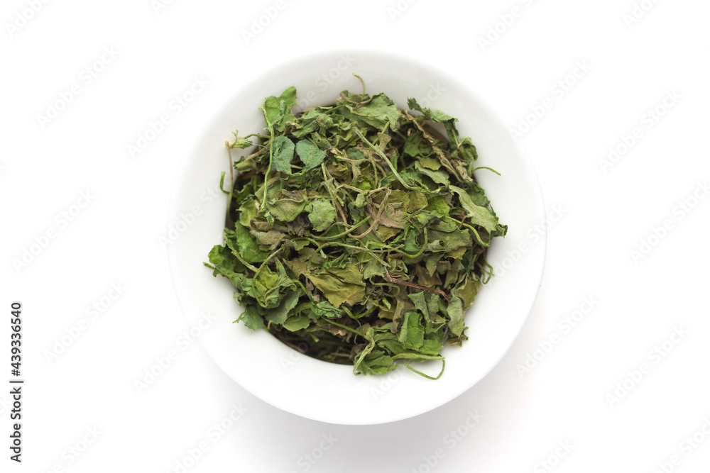 Macro close-up of Organic green dry Fenugreek leaves (Trigonella foenum-graecum) on white background. Pile of Indian Aromatic Spice. Top view Macro close-up of Organic green dry Fenugreek leaves (Trigonella foenum-graecum) on white background. Pile of Indian Aromatic Spice. Top view