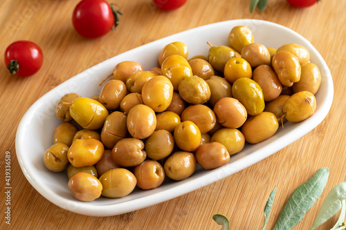 Scratched olive. Tasty organic scratched yellow olives in the plate. Olives on wooden background