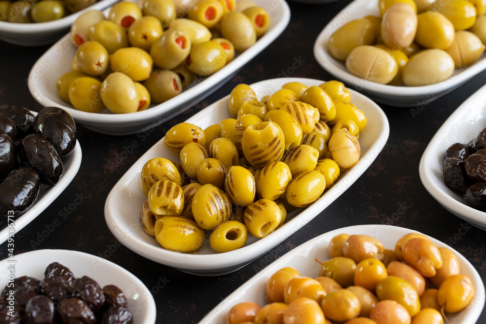 Assortment of olives on the plate in bulk. Organic black olives, Olive varieties Assortment of olives on the plate in bulk. Organic black olives, Olive varieties
