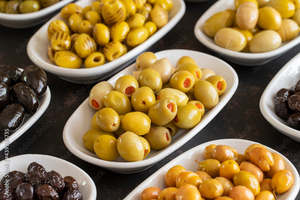 Assortment of olives on the plate in bulk. Organic black olives, Olive varieties Assortment of olives on the plate in bulk. Organic black olives, Olive varieties
