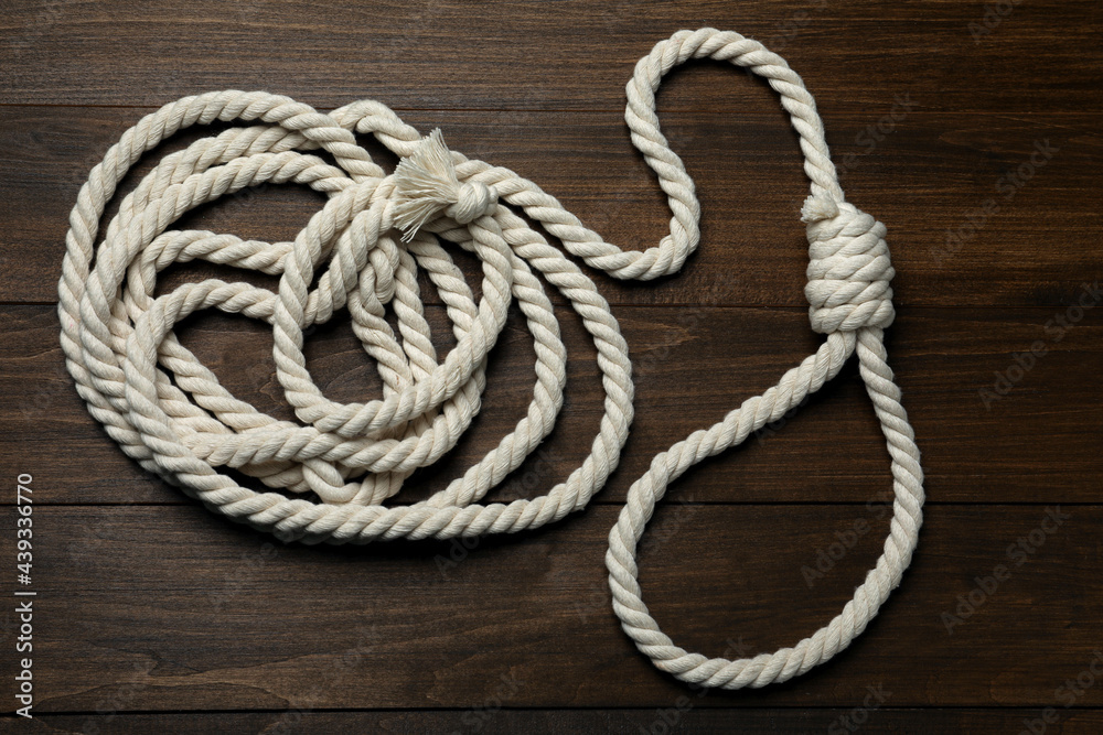 Obraz premium Rope noose on wooden table, top view