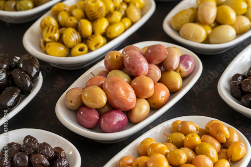 Assortment of olives on the plate in bulk. Organic black olives, Olive varieties