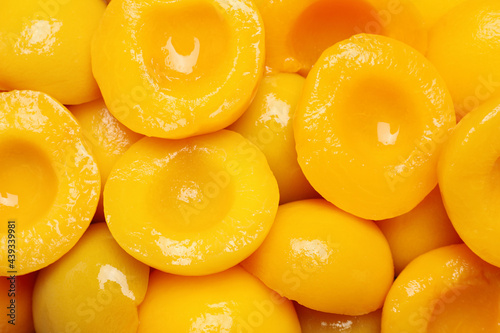 Obraz na plátně Halves of canned peaches as background, top view