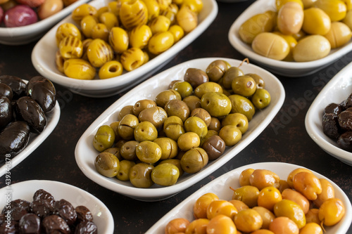 Assortment of olives on the plate in bulk. Organic black olives, Olive varieties