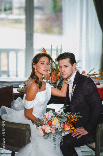 Close-up portraits of beautiful couple of newlyweds with bridal bouquet