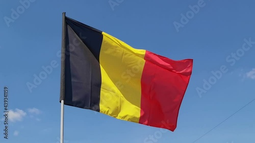 Belguim. National country flag on blue sky background. Flying fabric symbol. Tourism or travel summer day. international patriotic emblem. Nobody. Horizontal video photo