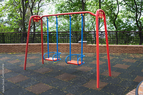 Two child swings in empty playground due coronavirus. Safety for children. Injury due to a fall. Baby swings metal.