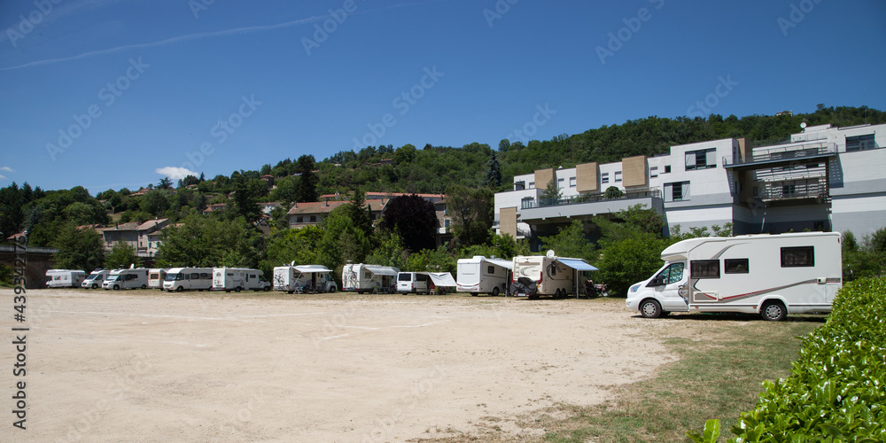 Camping cars alignés sur la place au pied de la montagne Camping cars alignés sur la place au pied de la montagne