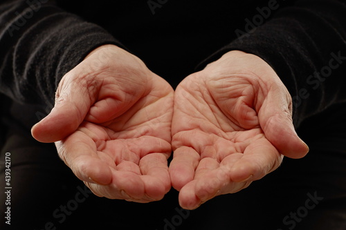 Hands of senior woman isolated on black backgound