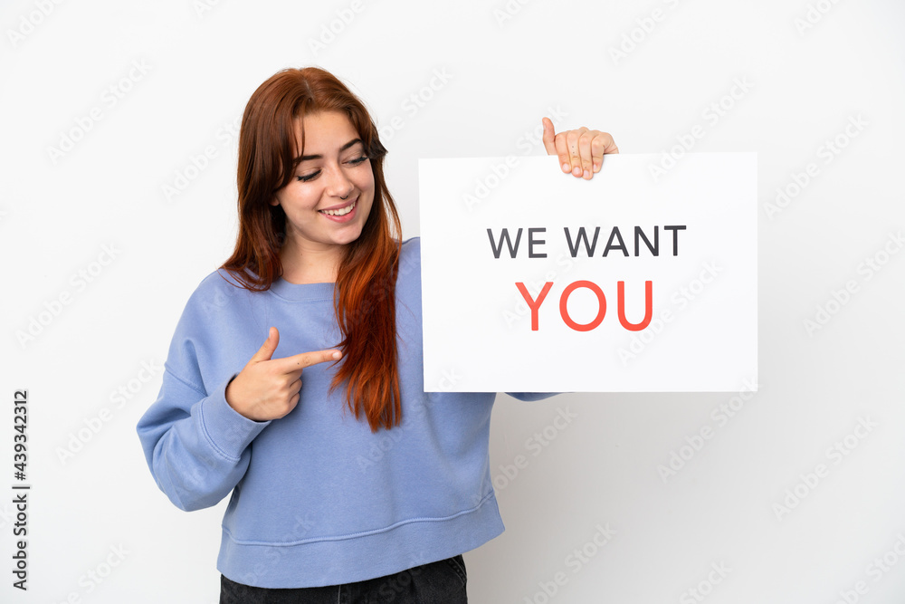 Young redhead woman isolated on white background holding We Want You board and pointing it Young redhead woman isolated on white background holding We Want You board and pointing it