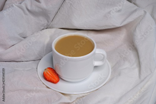 Coffee with milk on white bed linen.