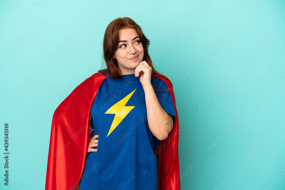 Young caucasian woman isolated on white background in superhero costume and thinking Young caucasian woman isolated on white background in superhero costume and thinking