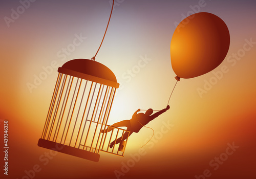 Concept de l’évasion et du rêve de liberté, avec un homme qui quitte une cage à oiseau en s’envolant avec un ballon de baudruche.