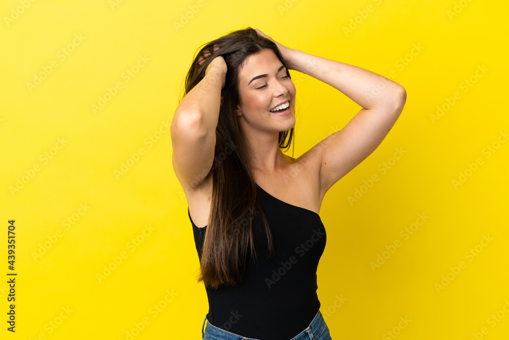 Young Brazilian woman isolated on yellow background laughing