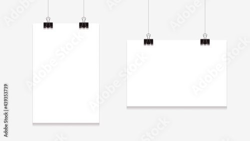 Blank posters mockup. Sheets hanging on binders on white background.