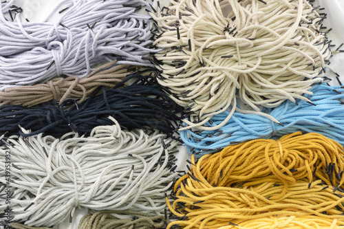 Background of many colorful synthetic handle cord for paper packets. Part of the packaging bags.