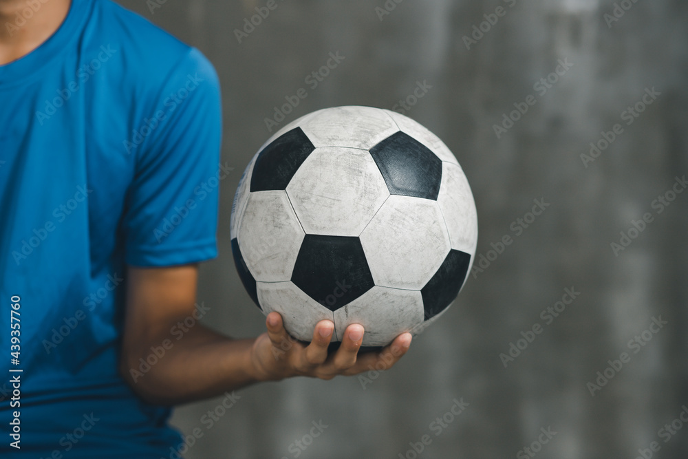 boy wearing blue shirt holding a classic football boy wearing blue shirt holding a classic football