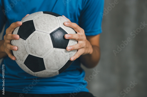 boy wearing blue shirt holding a classic football