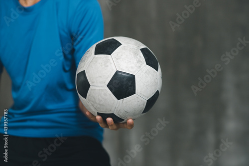 boy wearing blue shirt holding a classic football