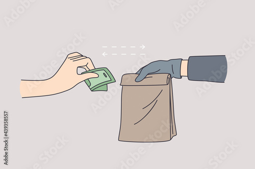 Delivery during coronavirus epidemic concept. Couriers hand in latex gloves holding paper bag with food and female hand in latex gloves giving money delivery service in pandemic time 