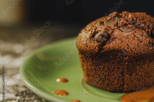 Homemade chocolate chips muffin with caramel on a green dish served gourmet