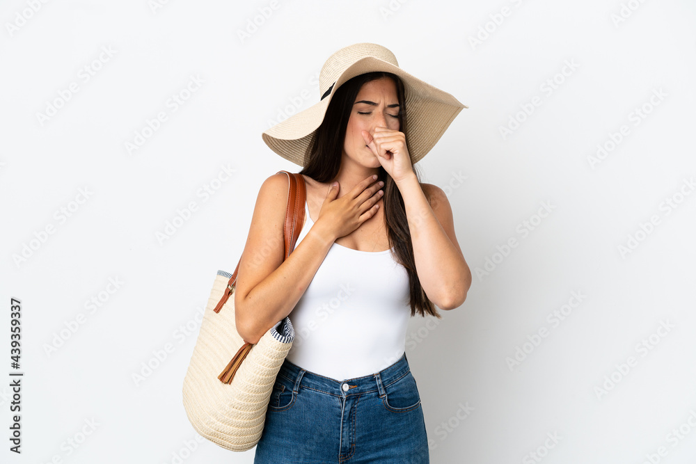Young Brazilian woman with Pamela holding a beach bag isolated on white background is suffering with cough and feeling bad Young Brazilian woman with Pamela holding a beach bag isolated on white background is suffering with cough and feeling bad