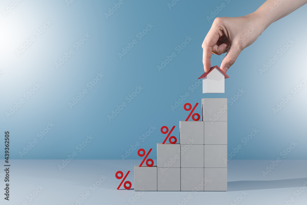 Obraz premium mortgage rates and Interest rate financial concept.Cement cube block shape with icon percentage and step up.Hand arranging cement block stacking as step stair with home.