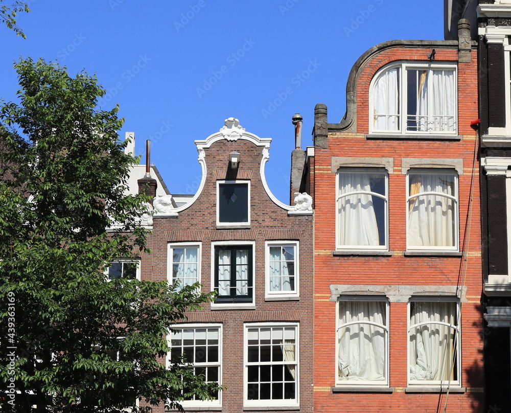 Fototapeta premium Amsterdam Canal House Facades Against a Blue Sky