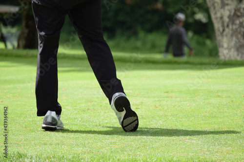 A man golfing, golf swing on a green golf course
