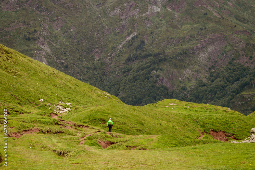 Un hombre mayor de excursión en un magnífico paisaje verde de alta montaña. Sendero que lleva al lago glaciar de Estanés en el lado norte (francés) de los Pirineos. Un hombre mayor de excursión en un magnífico paisaje verde de alta montaña. Sendero que lleva al lago glaciar de Estanés en el lado norte (francés) de los Pirineos.