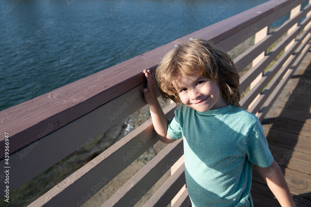 Leisure break. Happy boy child stand at promenade railing. Leisure time. Summer vacation Leisure break. Happy boy child stand at promenade railing. Leisure time. Summer vacation