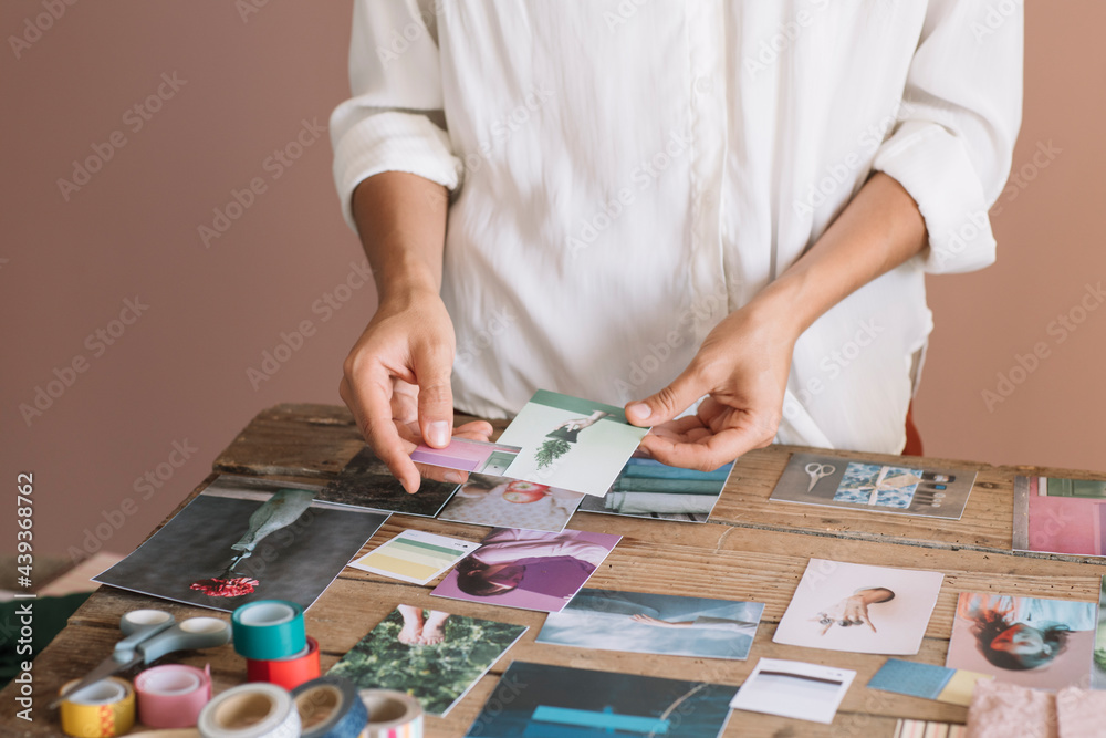 Young Woman's Hands Selecting Pictures for a Moodboard Young Woman's Hands Selecting Pictures for a Moodboard