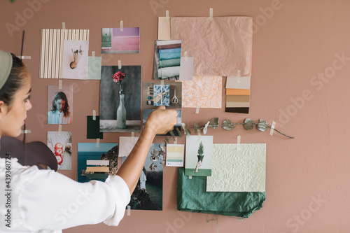 Young Woman Hanging Pictures on the Wall for a Moodboard photo