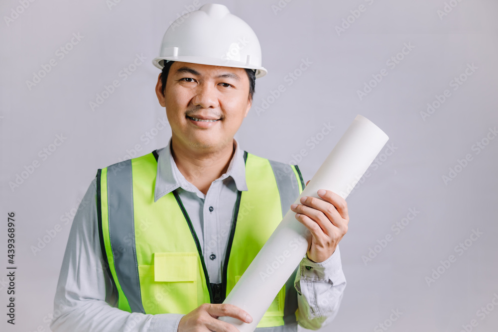 A young architect or engineer wearing a reflective vest and safety helmet in construction work, a young professional architect holding a blueprint for his design work. A young architect or engineer wearing a reflective vest and safety helmet in construction work, a young professional architect holding a blueprint for his design work.