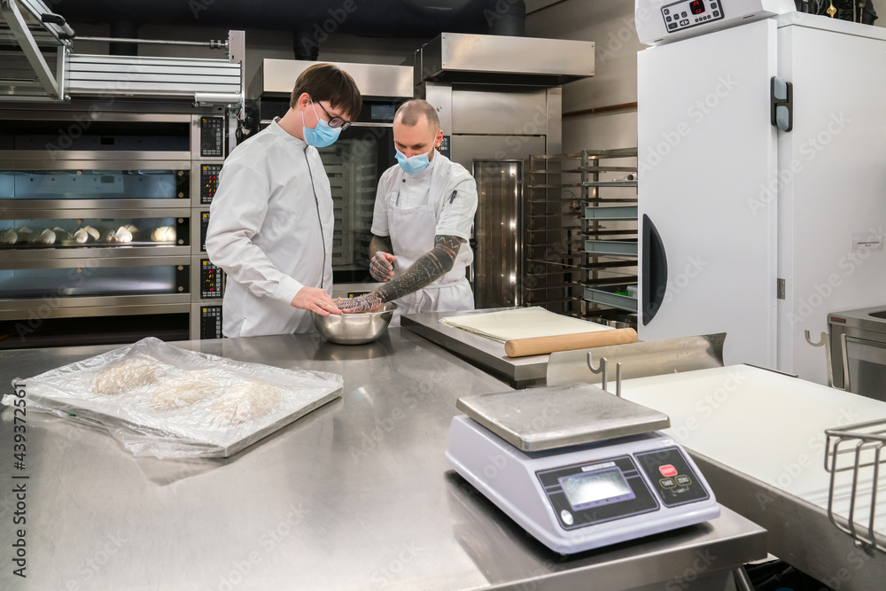 Bakers Wearing Face Mask Working At Kitchen
Bakers Wearing Face Mask Working At Kitchen