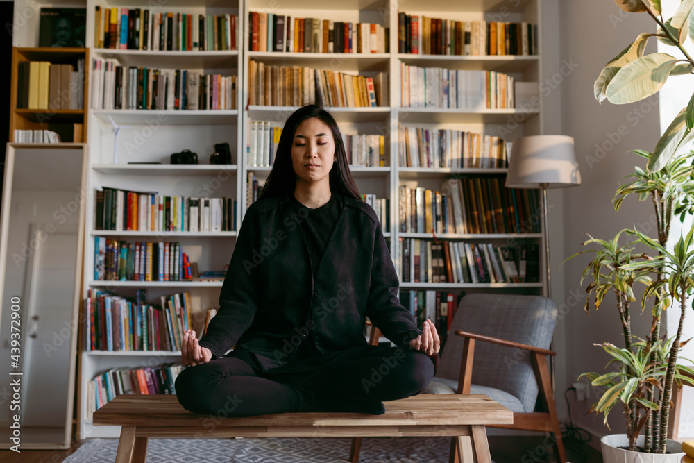 female east asian woman practicing mindfulness at home female east asian woman practicing mindfulness at home