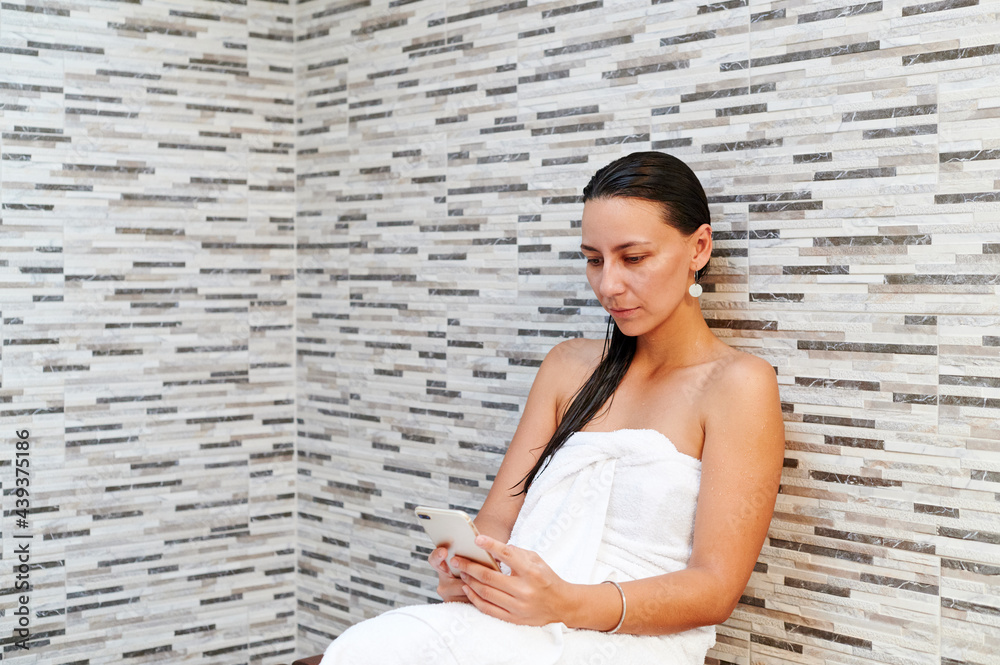 Young woman reading a text after a shower Young woman reading a text after a shower