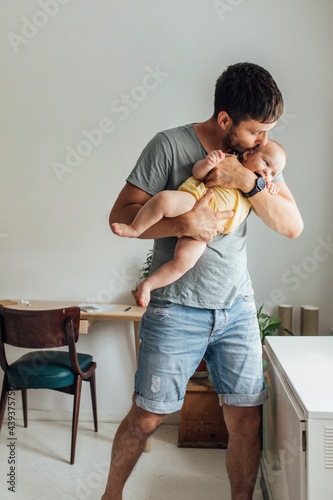 Happy Baby Enjoying In Some Kisses Given To Her By Her Father photo