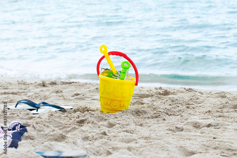 Summer beach toys and flip flops on the beach. holiday and vacations concept. Summer beach toys and flip flops on the beach. holiday and vacations concept.