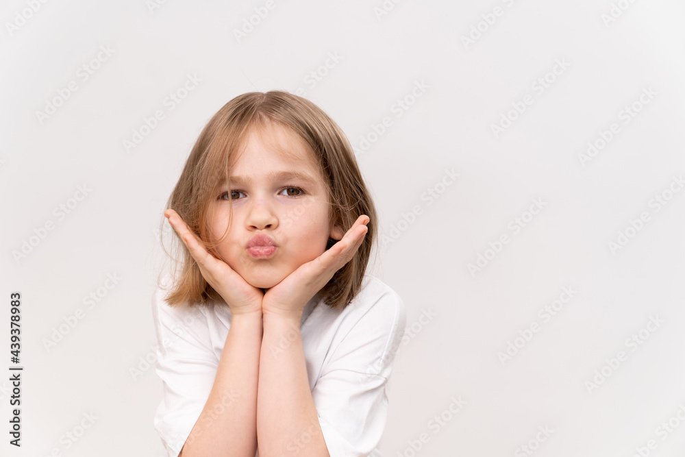 happy girl with haircut quad holds hands in the face on white background