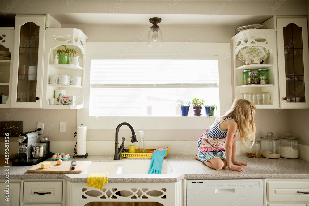 Girl in apron on kitchen counter Girl in apron on kitchen counter