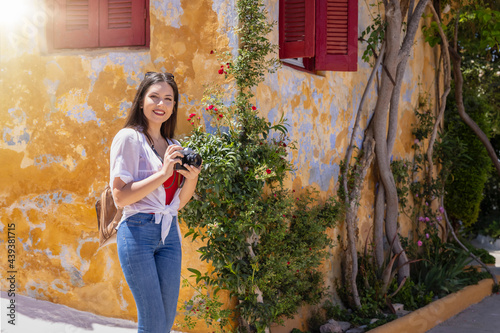 A young woman with backpack explores the old town of Athens, Greece, so called Plaka, during her summer travel time